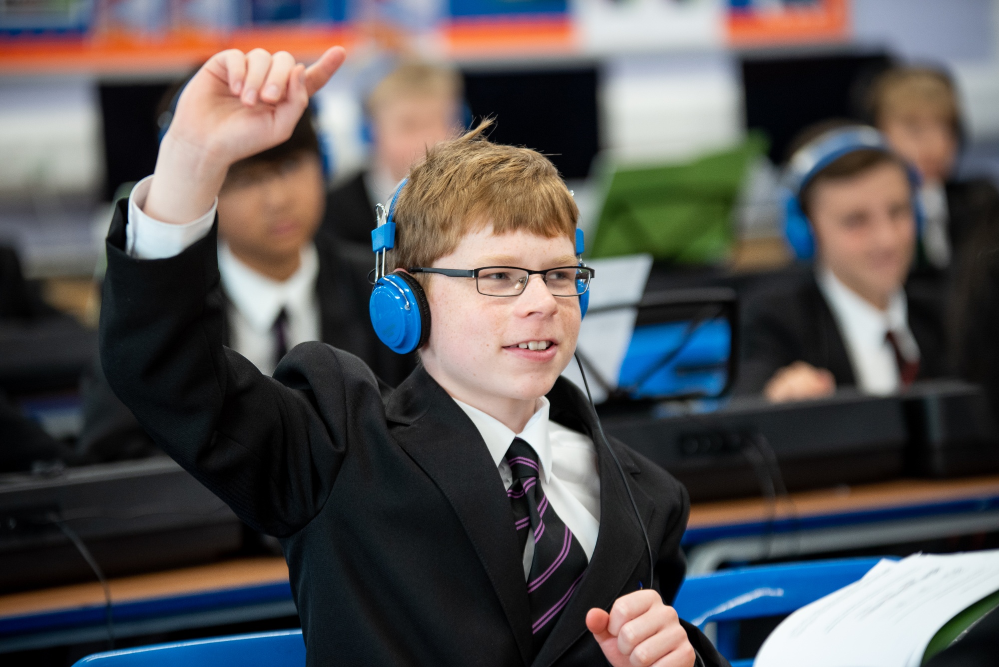 students at a keyboard with hand up