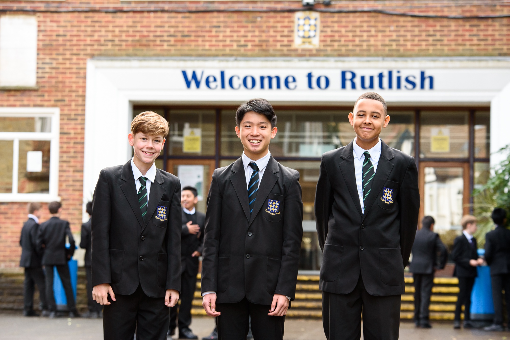 Rutlish students standing under the Welcome to Rutlish sign
