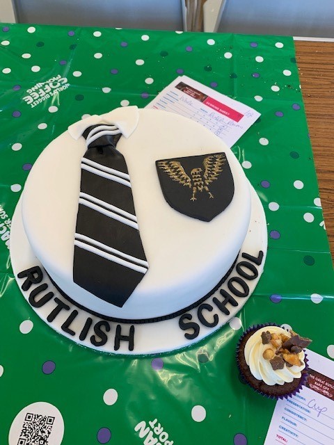 picture of a cake with a school tie  and a Romans school badge
