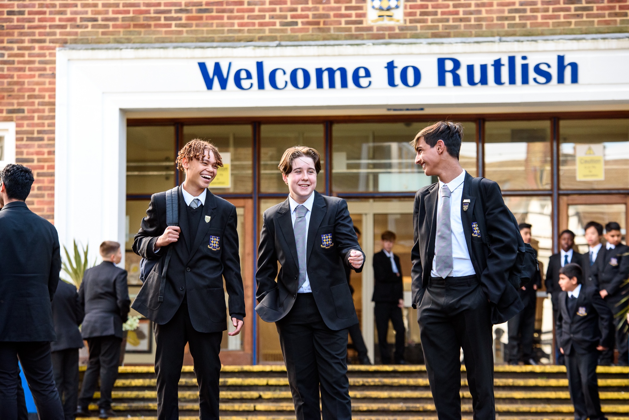 students near the "Welcome to Rutlish" sign