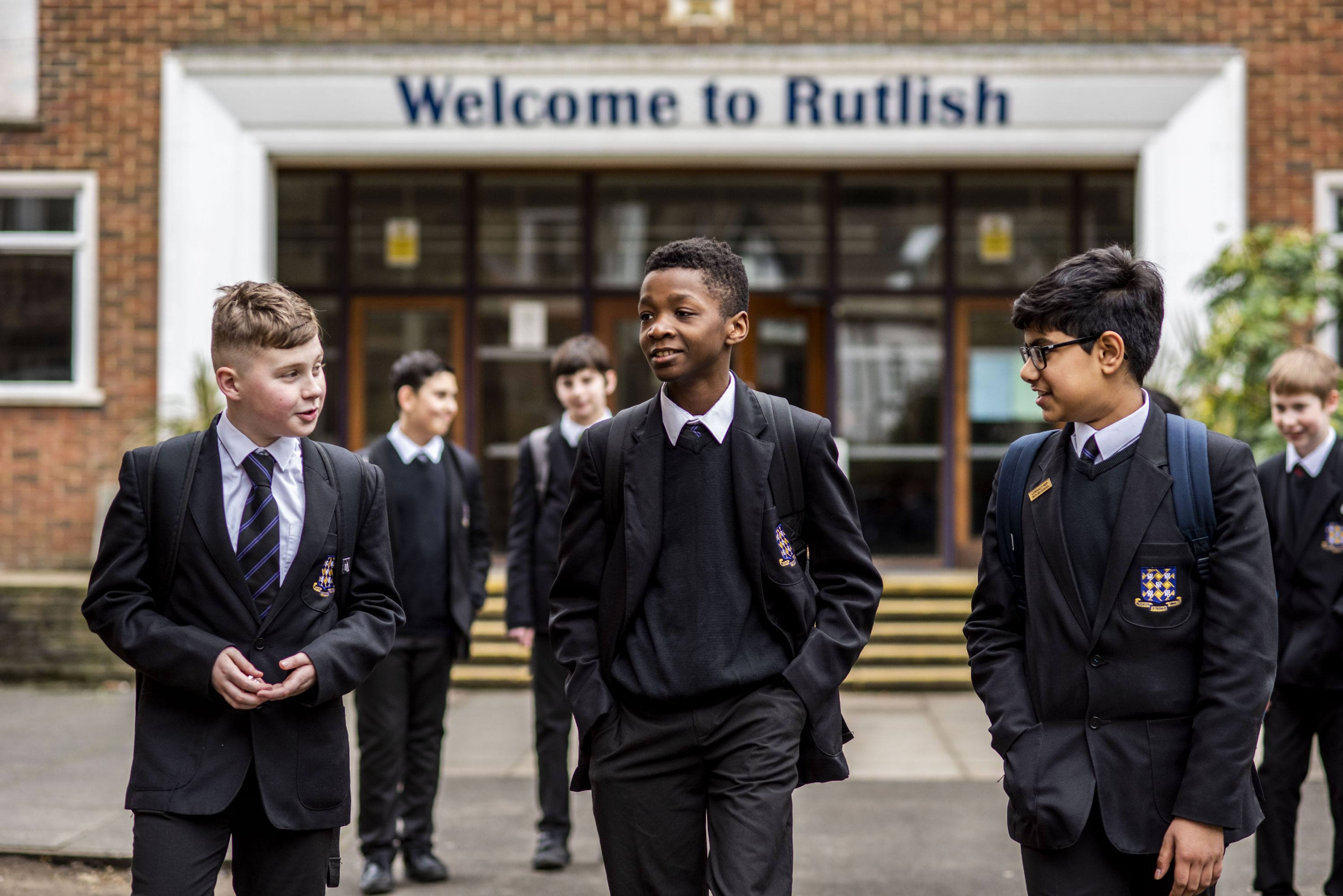 students near the "Welcome to Rutlish" sign